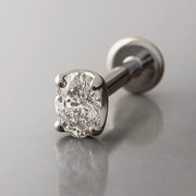 14k white gold 3mm oval-cut diamond flat back labret, angled studio shot highlighting 4-prong setting