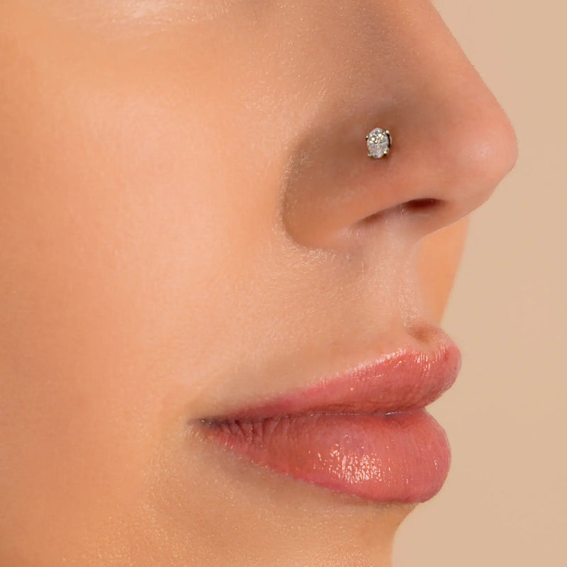 14k white gold oval-cut diamond flat back stud shown in nostril piercing, side profile on model