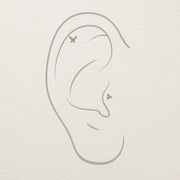 Placement diagram showing diamond butterfly studs at helix and conch positions on illustrated ear