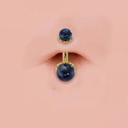 Black Akoya pearl 14k gold navel ring shown in pierced belly button, scroll setting detail visible