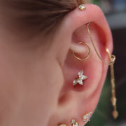 14K yellow gold pear fan CZ stud worn in lobe piercing with gold ear stack, lifestyle close-up