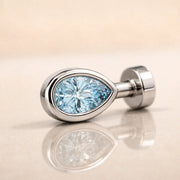 14k white gold aquamarine pear-cut floating belly ring laying on side, top view