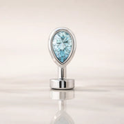 14k white gold floating navel ring with aquamarine teardrop stone, front view on reflective surface