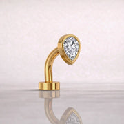 Side profile of 14k yellow gold petite teardrop floating belly ring with CZ, showing curved barbell shape