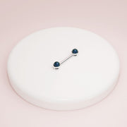 14K white gold black Akoya pearl nipple barbell displayed on white ceramic tray for scale