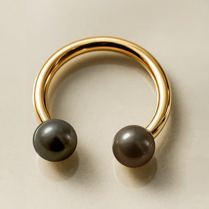 14K yellow gold circular barbell with dual peacock pearls, angled overhead view on neutral background