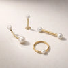 14K yellow gold pearl body jewelry collection showing straight barbell alongside labret, curved barbell, and hoop