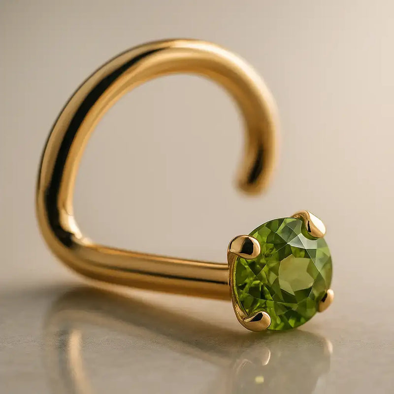 14K yellow gold peridot nose ring twist style with prong-set green stone, angled studio view
