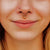 Close-up of a person wearing a gold nose ring with a small red earring.