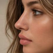 Clear glass nose and labret piercing retainers worn on a model, side profile showing how discreet clear glass retainers look