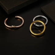 18K rose gold, yellow gold, and white gold plain clicker hoops open on dark reflective surface