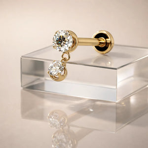 14k yellow gold dual diamond dangle flat back labret resting on glass, showing post and flat back