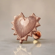 14k rose gold radiant heart flat back labret stud with sunburst ridged detail, angled studio shot