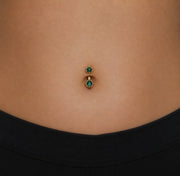 Model wearing the Reina London Blue Topaz Crown Curved Belly Ring in 14k gold