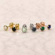 Grouping of Reina earrings with different colored gemstones on a light background