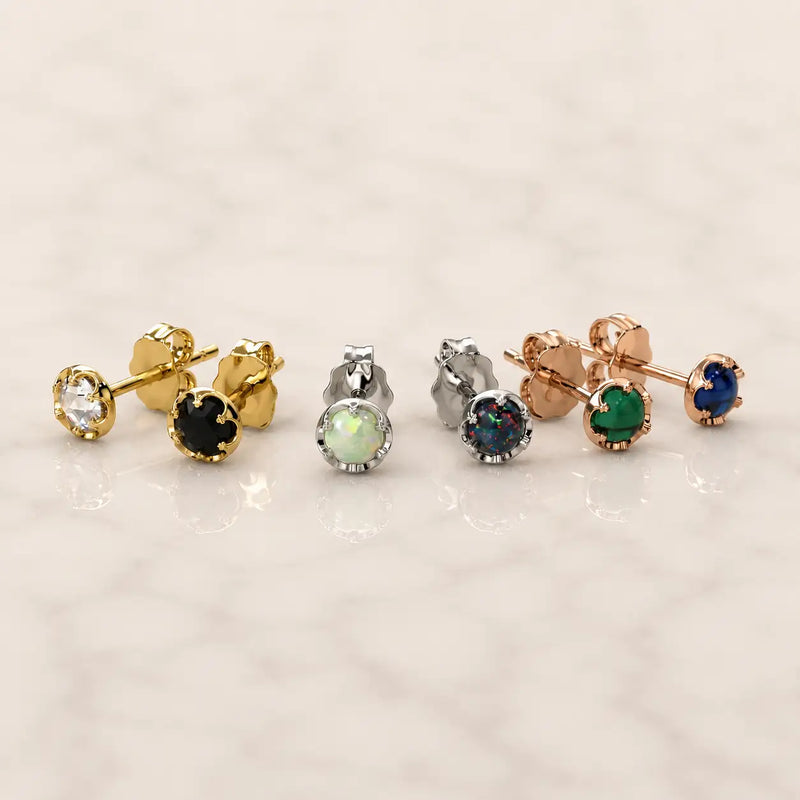 Grouping of Reina earrings with different colored gemstones on a light background