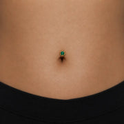 Model wearing the Reina Zambian Emerald Crown Floating Navel Ring in 14k gold