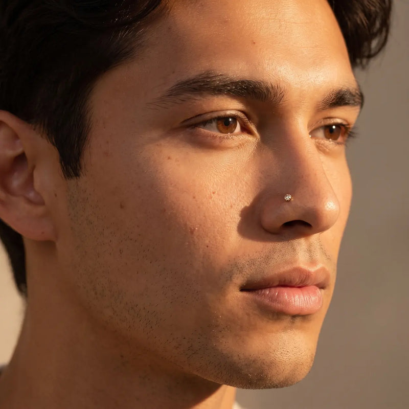 3mm Reina rose cut diamond nose ring in 14k yellow gold worn in a nostril piercing, close-up on a male model