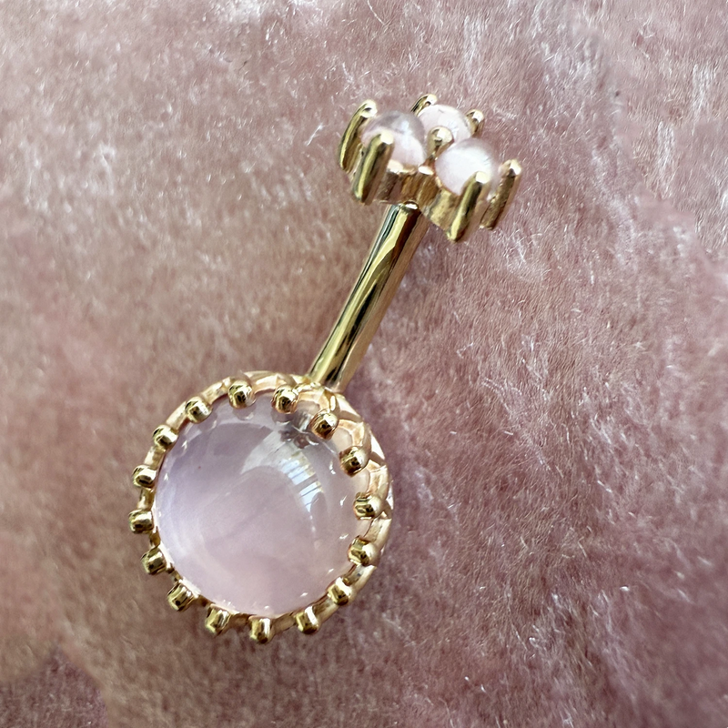 14k yellow gold rose quartz navel ring shown on pierced belly for fit and scale reference