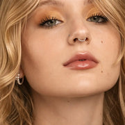 Slim platinum seam ring hoop worn as septum ring on model, front-facing close-up beauty shot