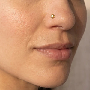 Model wearing the Diamond Sunburst Nose Ring in 14k yellow gold in a nostril piercing
