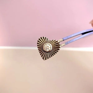 14k gold diamond sunburst heart earring held in tweezers for size reference