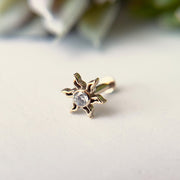 Close-up of 14K gold sunburst helix stud top showing CZ bezel setting and ray detail