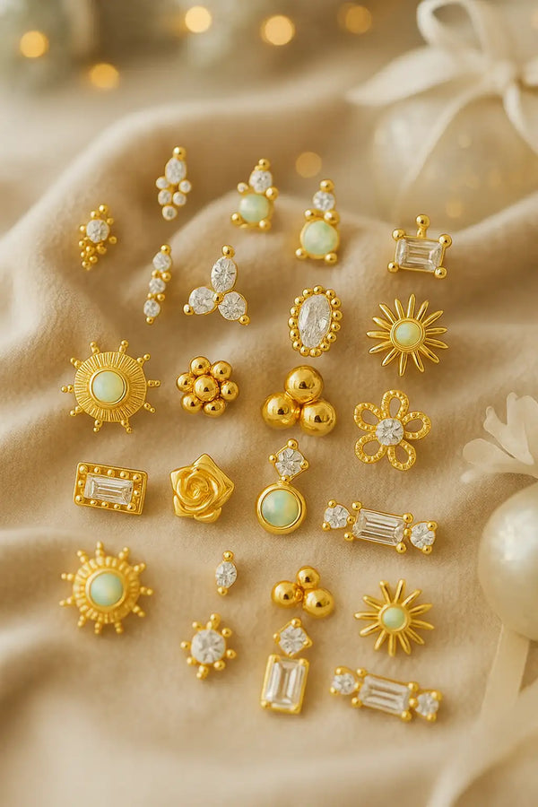 Collection of gold and gemstone earrings on a beige fabric background
