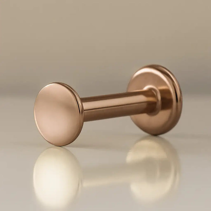 14K rose gold 3mm polished disc flat back labret, angled view showing warm pink-gold finish