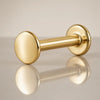 14K yellow gold polished disc flat back labret stud, angled view showing disc end and flat backing
