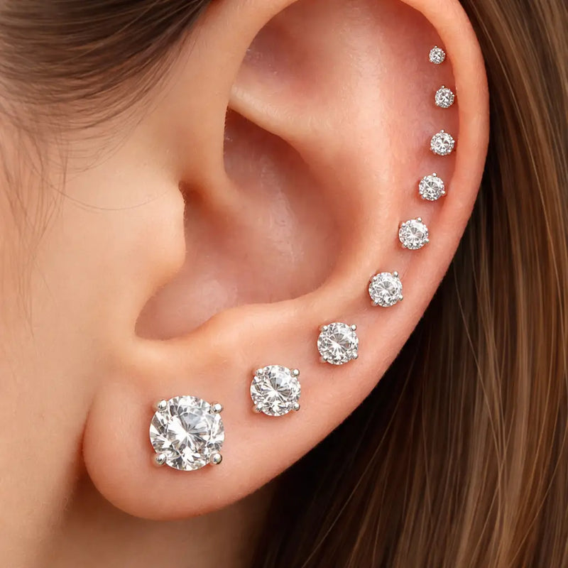 Diamond prong studs in graduated sizes stacked from lobe to cartilage on model's ear