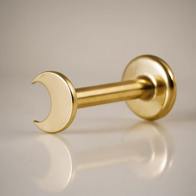 14k yellow gold crescent moon flat back labret stud, angled view showing post and flat disc backing