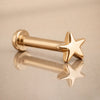 14k yellow gold star flat back labret stud angled on reflective surface showing post and disc backing