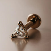 14k rose gold 3mm triangle diamond flat back labret stud, angled lifestyle shot on warm background