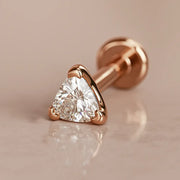 14k rose gold trillion-cut diamond flat back labret stud, angled shot on warm marble surface
