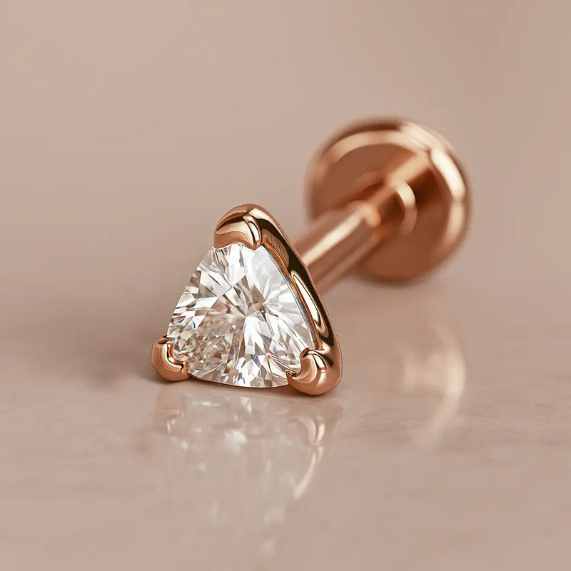 14k rose gold trillion-cut diamond flat back labret stud, angled shot on warm marble surface