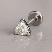 14k white gold trillion-cut diamond flat back stud, angled lifestyle shot on marble surface
