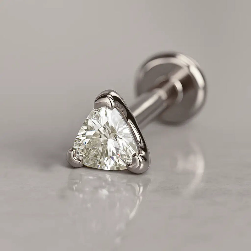 14k white gold trillion-cut diamond flat back stud, angled lifestyle shot on marble surface