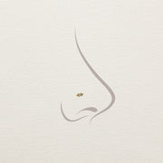 14k yellow gold Bali Blossom diamond threadless end shown on illustrated nose piercing placement