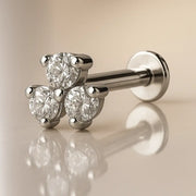 14k white gold triple CZ flat back labret with three prong-set stones, angled view on reflective surface