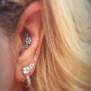 Triple flower diamond flat back stud in helix piercing styled in a curated ear with multiple studs