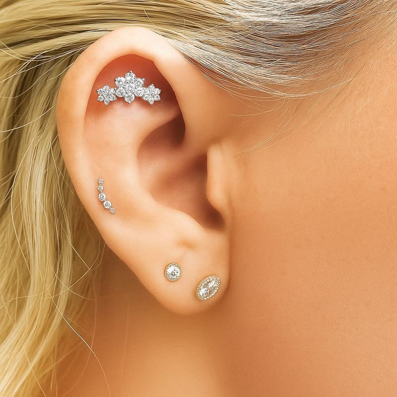 Triple flower CZ flat back stud worn in helix piercing, styled with other ear jewelry on model
