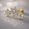 14k yellow gold triple flower flat back labret with round-cut stones on marble surface, angled view