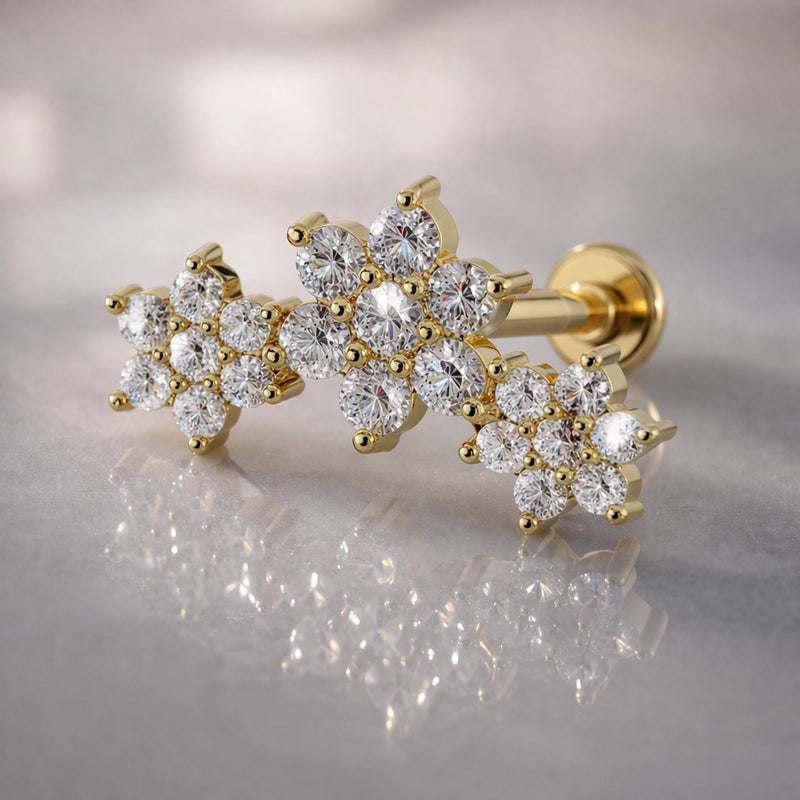 14k yellow gold triple flower flat back labret with round-cut stones on marble surface, angled view