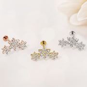 Triple flower flat back stud in rose gold, yellow gold, and white gold side by side near white flower