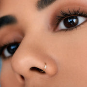 14K gold dual-diamond seam ring hoop worn as a nose ring, close-up on model's face