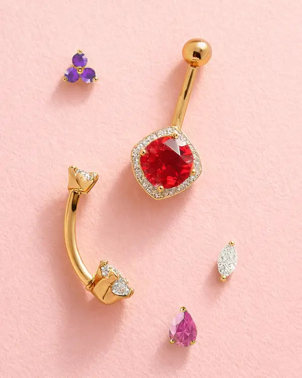 Gold and gemstone jewelry on pink background