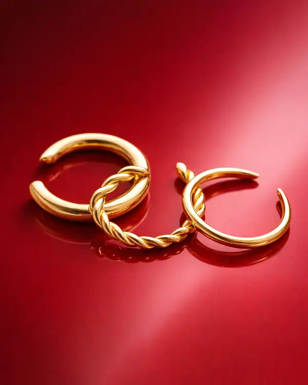Gold ear cuffs on red background