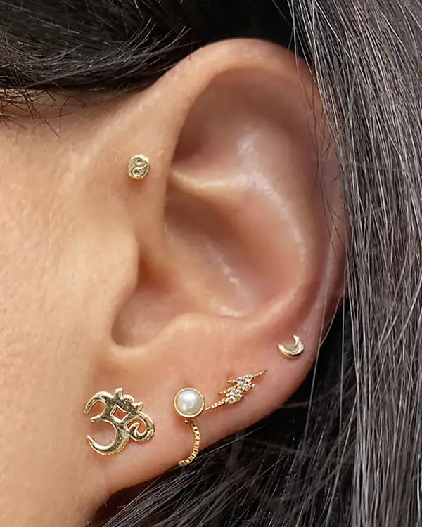 Close-up of an ear with gold earrings