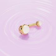 14k yellow gold dual Akoya pearl belly ring laid flat on rippled pink surface